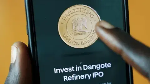 Reuters A close-up of a phone screen with the Bamboo logo and the words "Invest in Dangote Refinery IPO".